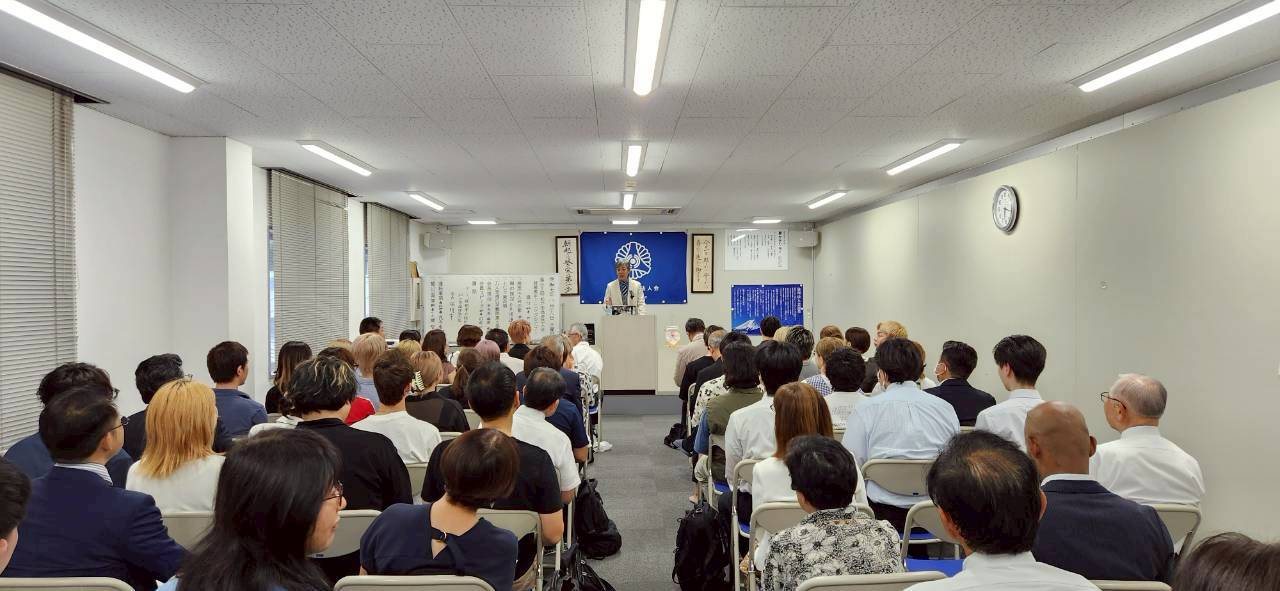 講話に聞き入る満席の会場