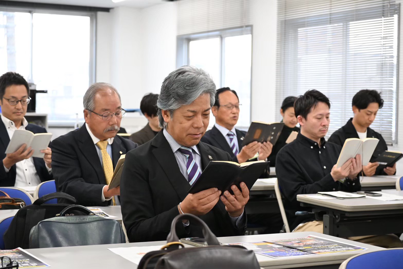 「万人幸福の栞」を声に出して読む参加者たち